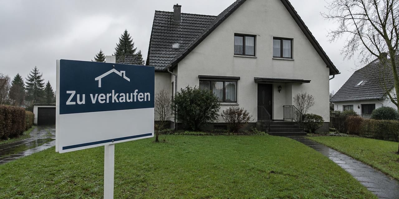 Haus mit Verkaufsschild an einem trüben Tag